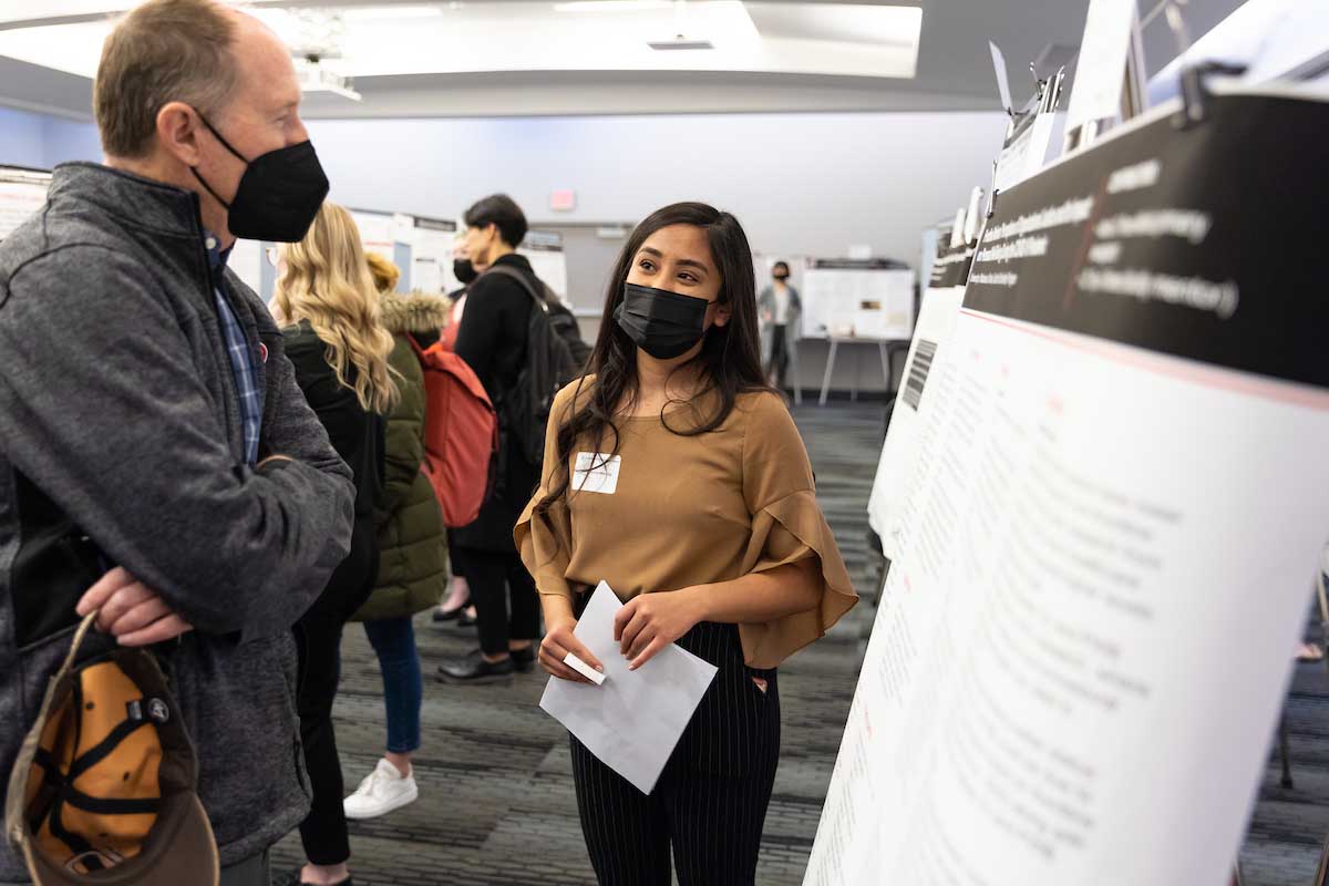 A student presents her research to UNO professor Dr. Neal Grandgennett