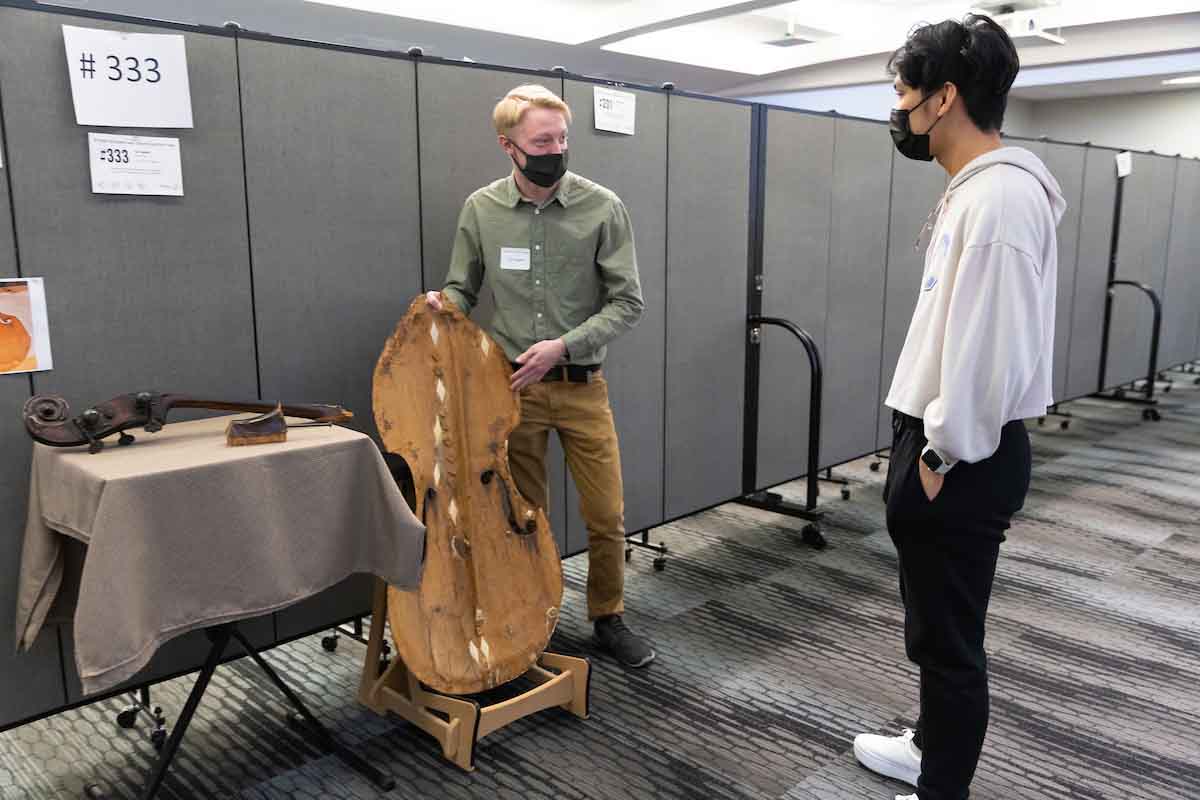 A student demonstrates the restoration of a guitar.