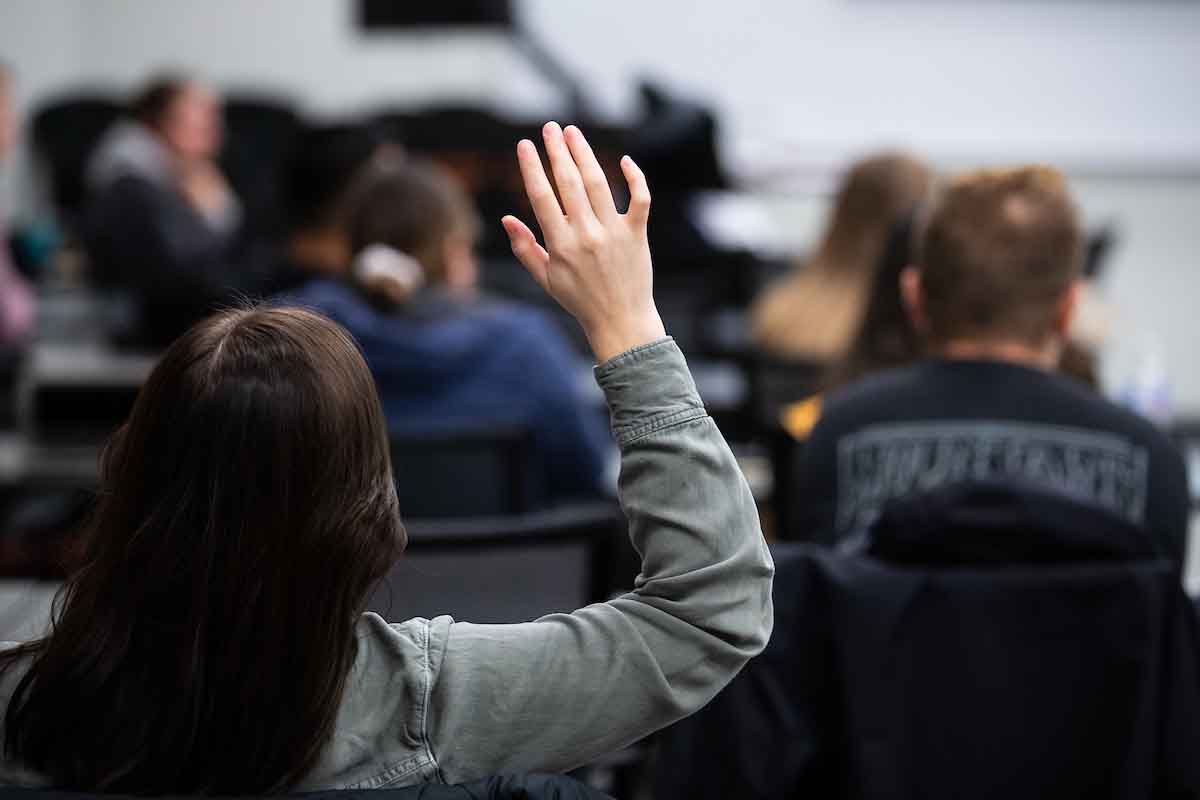 A student raises her hand in a public health course.