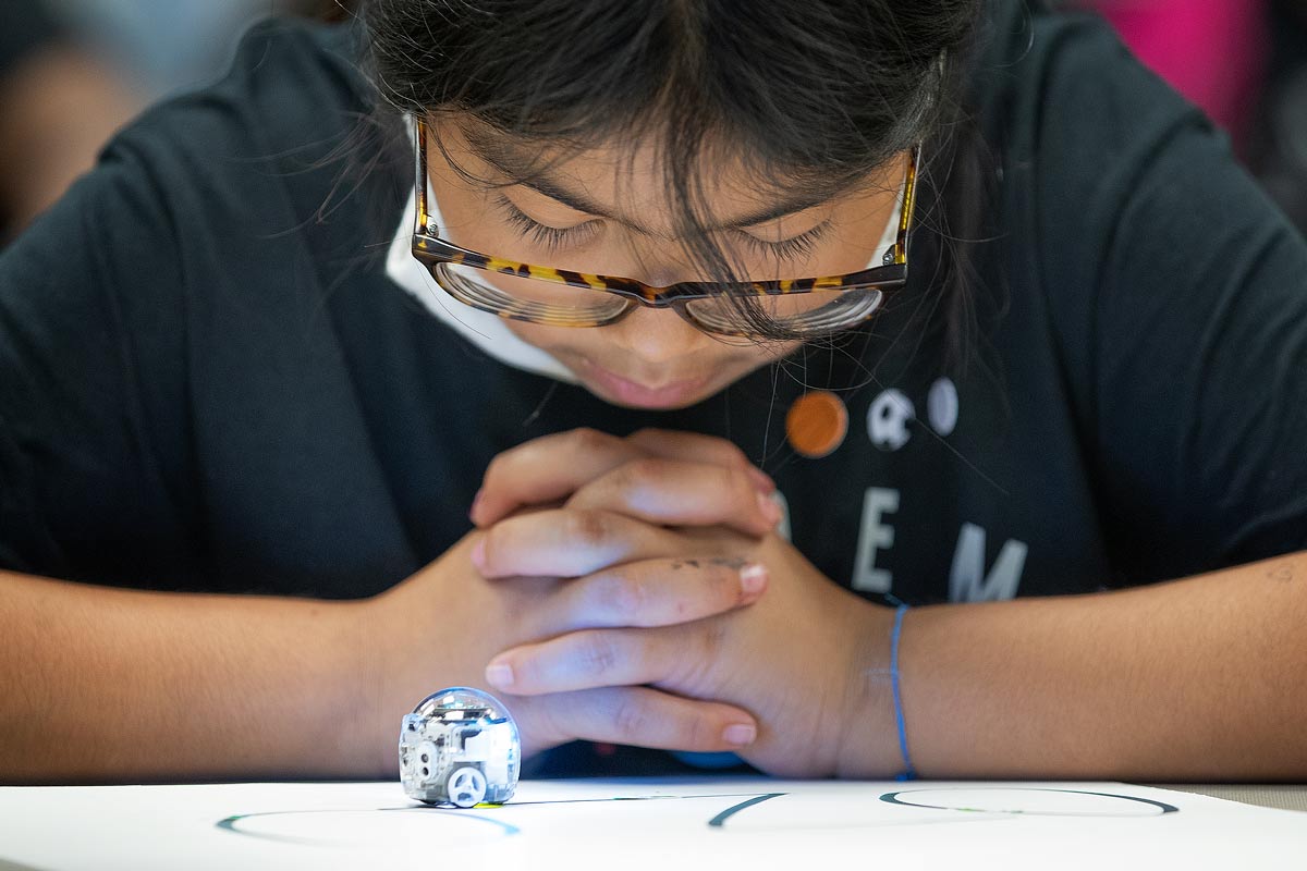 A camper watches an Ozobot.