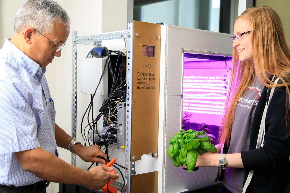 Kiran Bastola, Ph.D., with his food computer and a student.