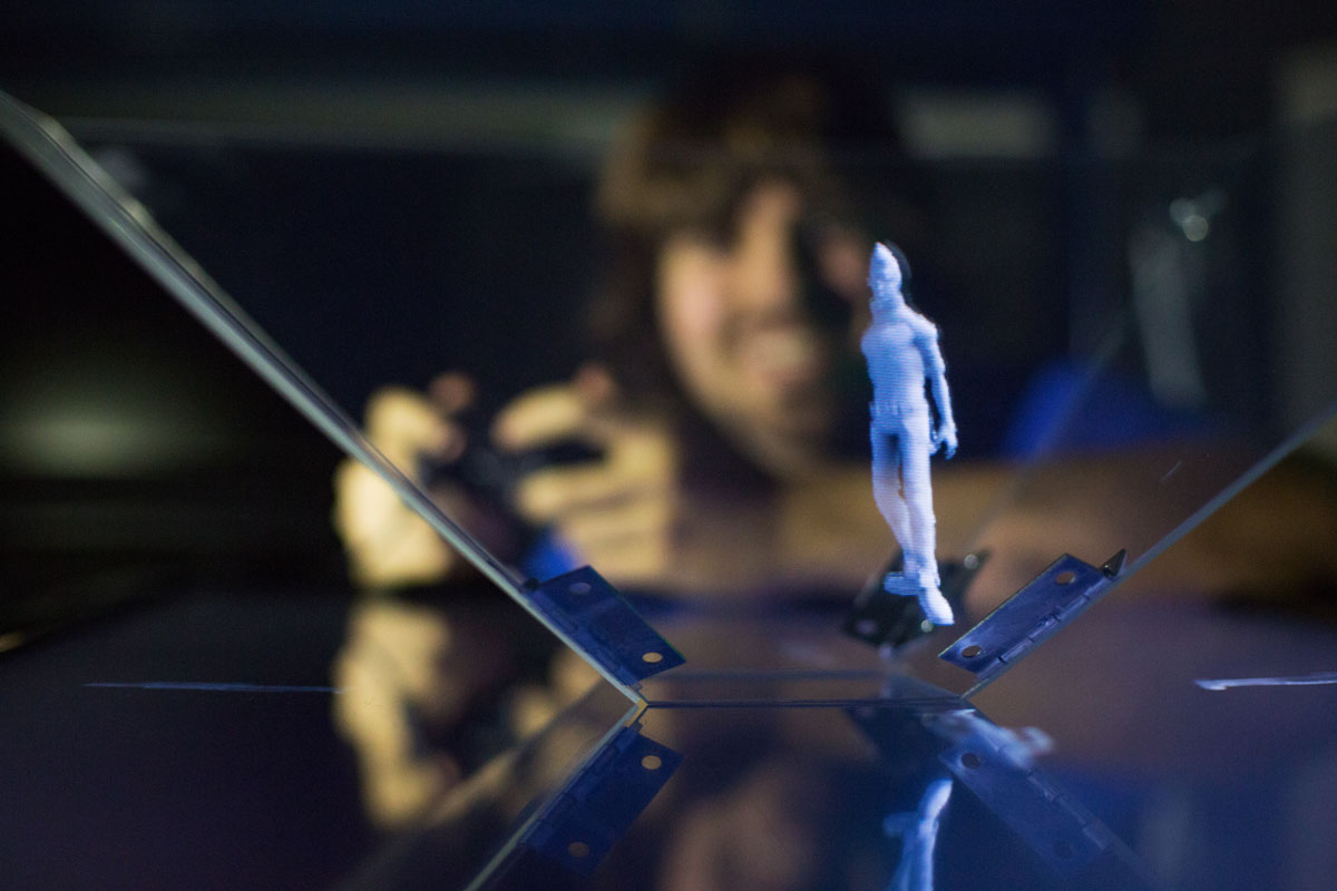 A College of IS&T student experiments with a hologram figure.
