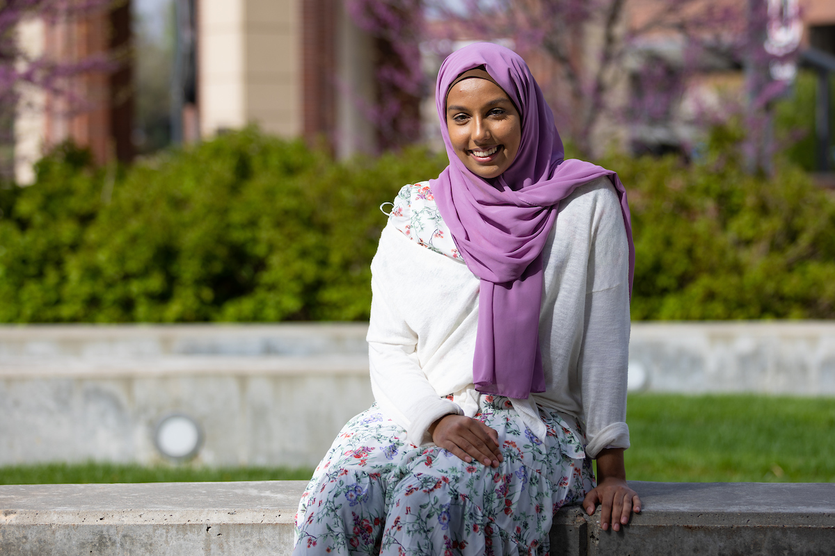 Qulagi sits on a bench at UNO's campus. 