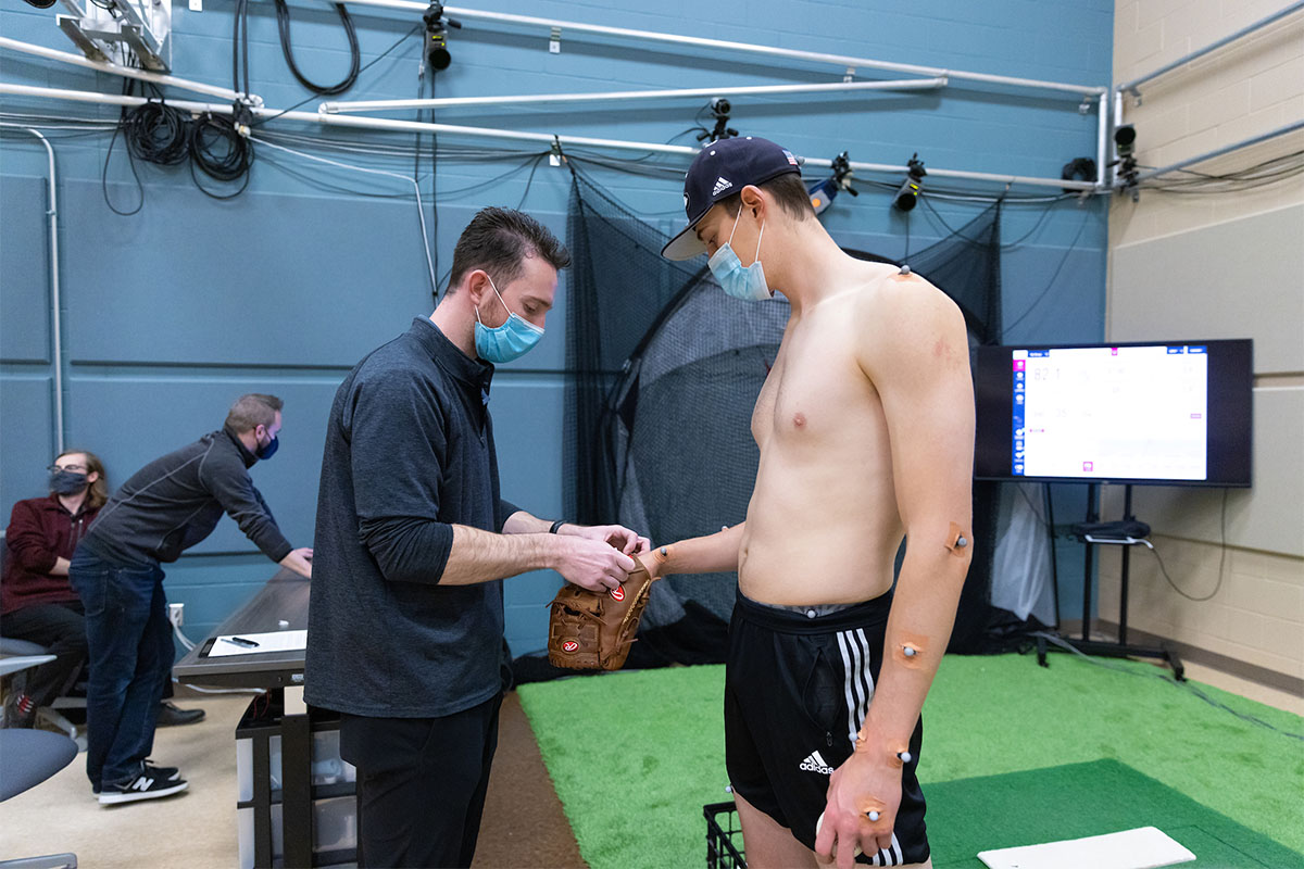Researchers within UNO's Department of Biomechanics outfit Seebach with motion sensors to be used with motion capture cameras. Together, these can provide a holistic view of his pitching motion.