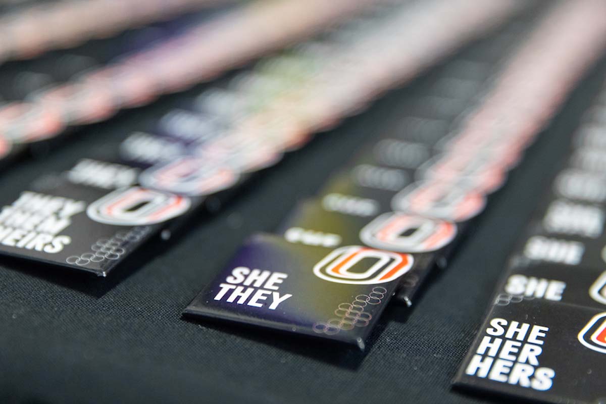 A row of buttons with pronouns they/them/theirs, she/they, and she/her/hers with the UNO logo