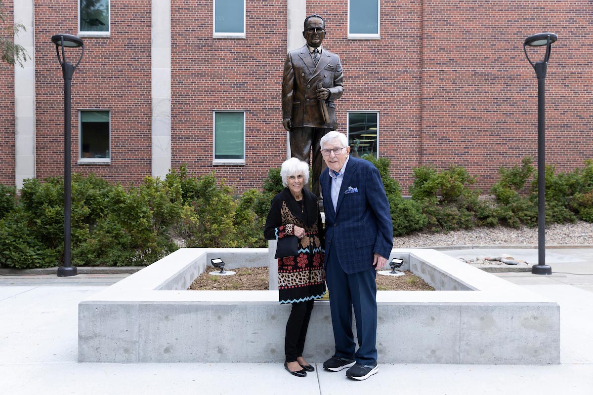Beverly and Al Thomsen pose in front of the Phillip Milo Bail statue. Bail served as president of Omaha University from 1948-1965.
