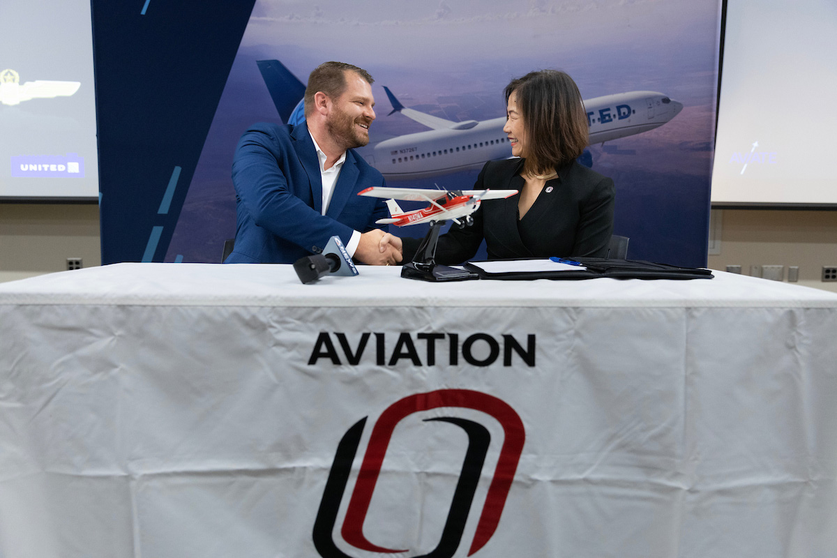 United Airlines Perry Lewis, left, and Chancellor Joanne Li, Ph.D., CFA, sign the Aviate program agreement. 