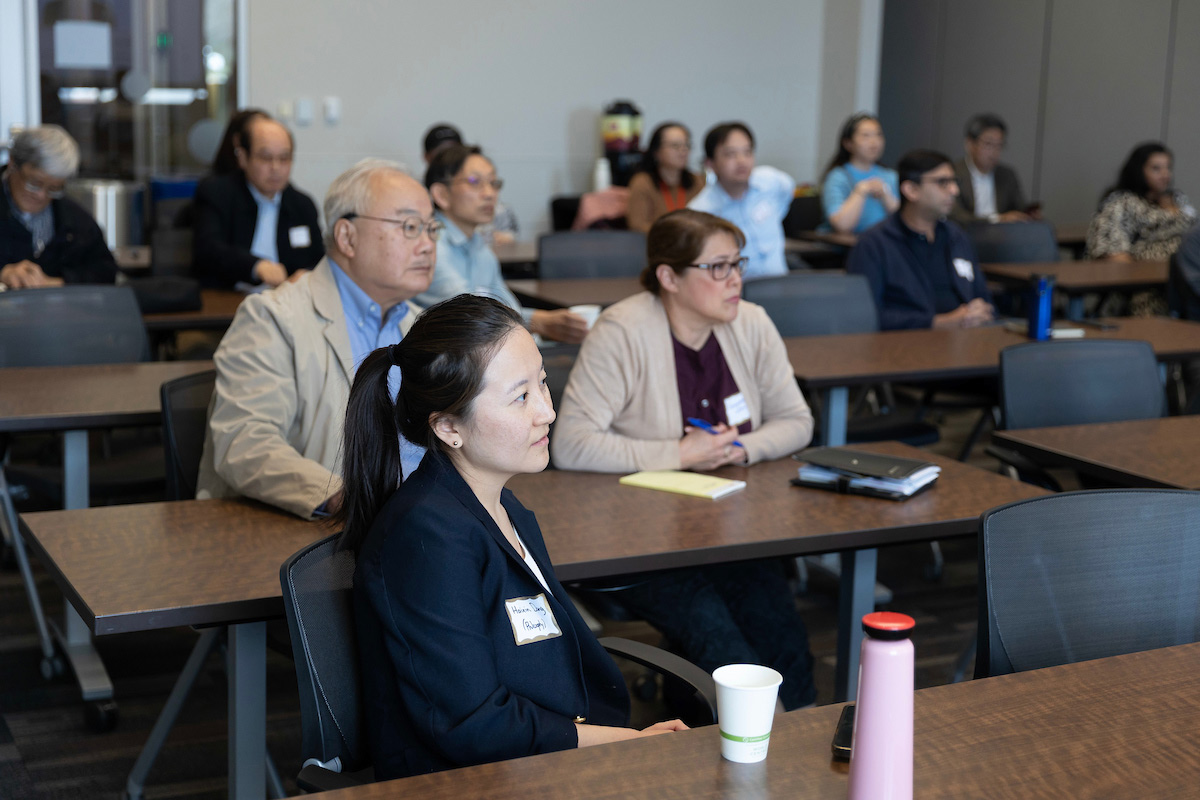 Meeting attendees watching Dr. He's presentation