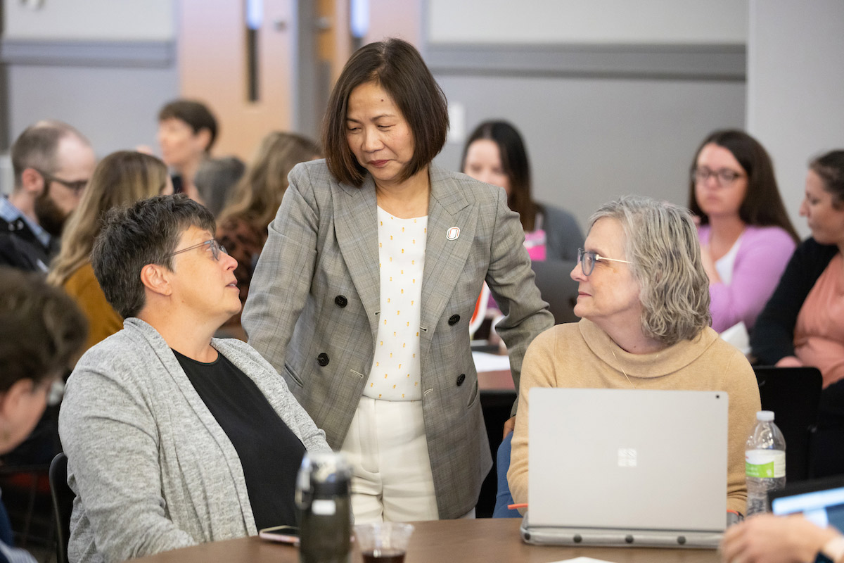 Chancellor Joanne Li, Ph.D., CFA chatting with people at the forum