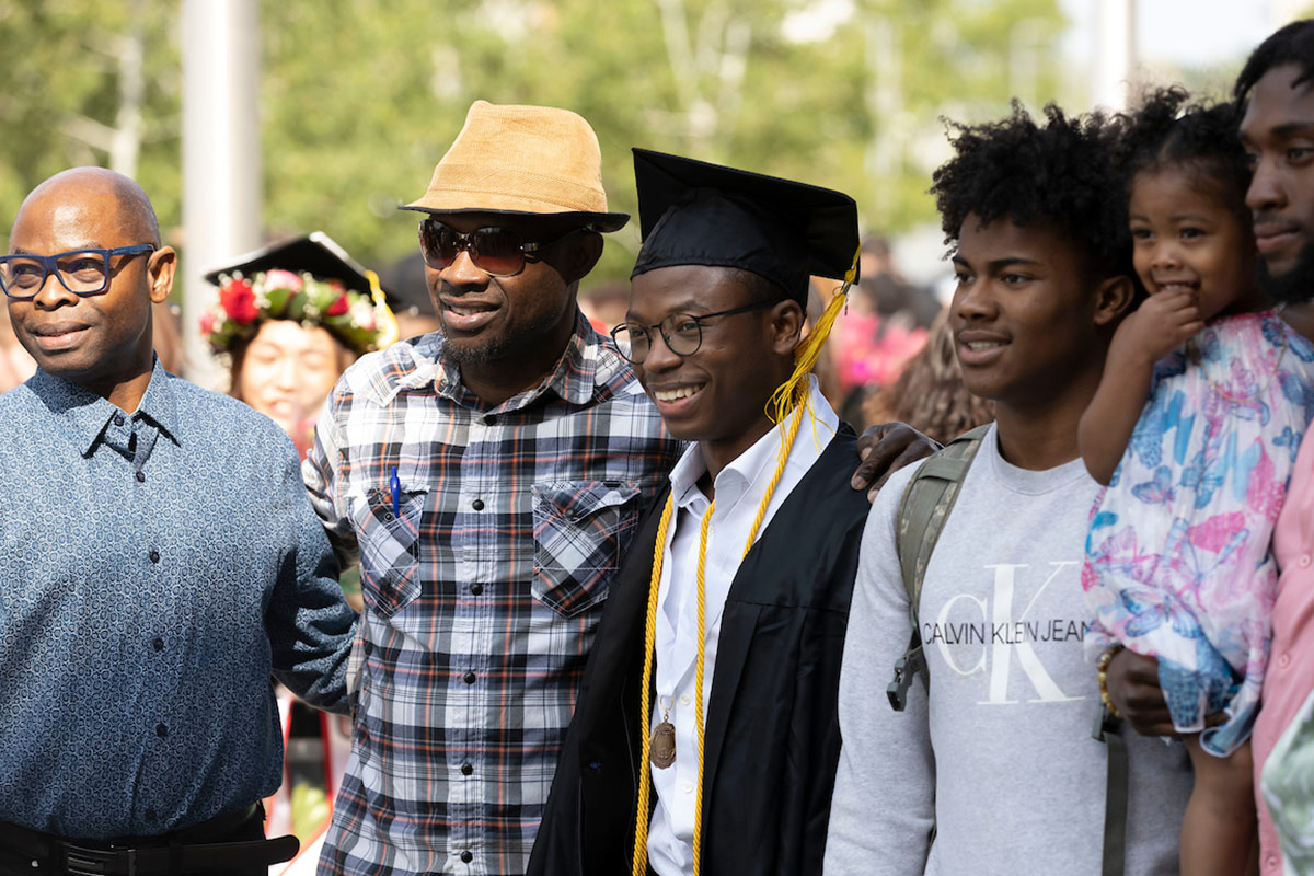 Families and loved ones celebrate with their graduates outside of Baxter Arena