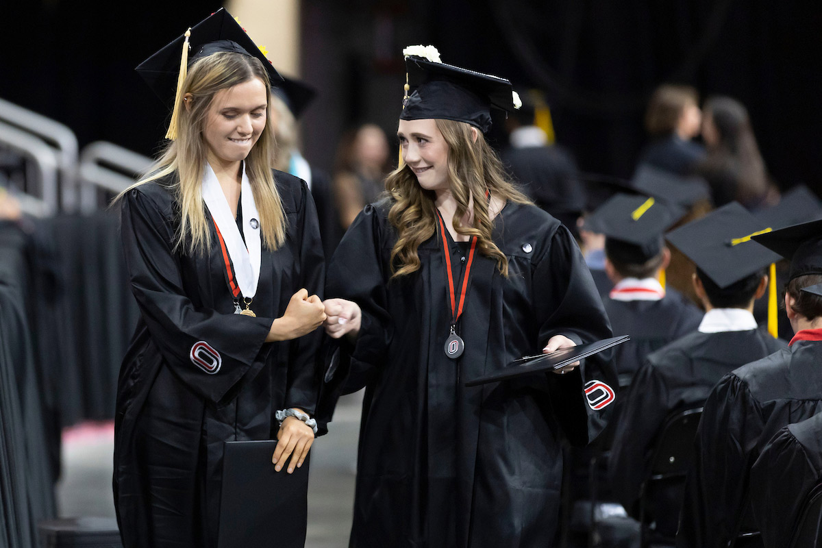 Two Spring 2023 graduates celebrate after receiving their diplomas at the May 2023 commencement ceremonies held on May 19, 2023. Many graduates are among the 4,600+ Mavericks named to the Dean's and/or Chancellor's list for the Spring 2023 semester.