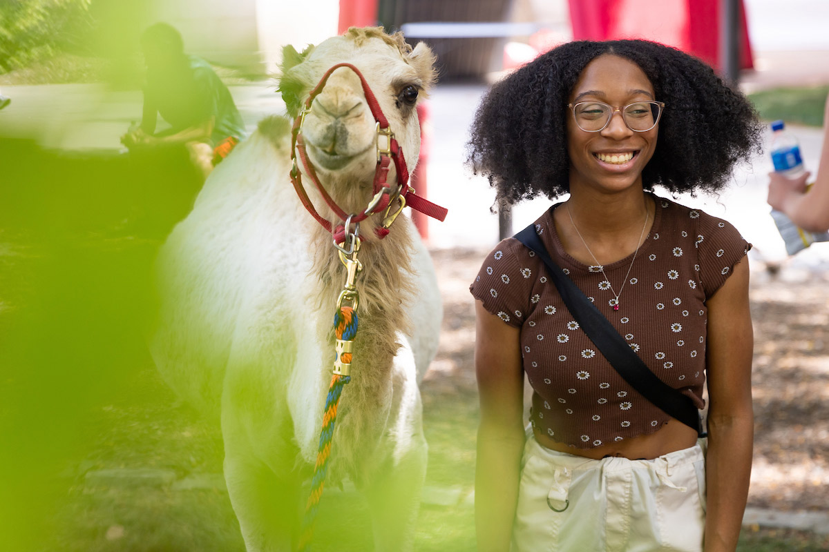 A student gets a photo with Maverick the Camel at the "Hump Day" event during Durango Days.