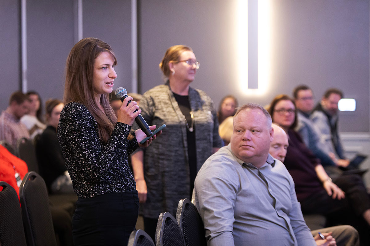 Bethany Hughes, president of UNO's Staff Advisory Council and director of the CBA Scholars Academy, asks a question at the event.