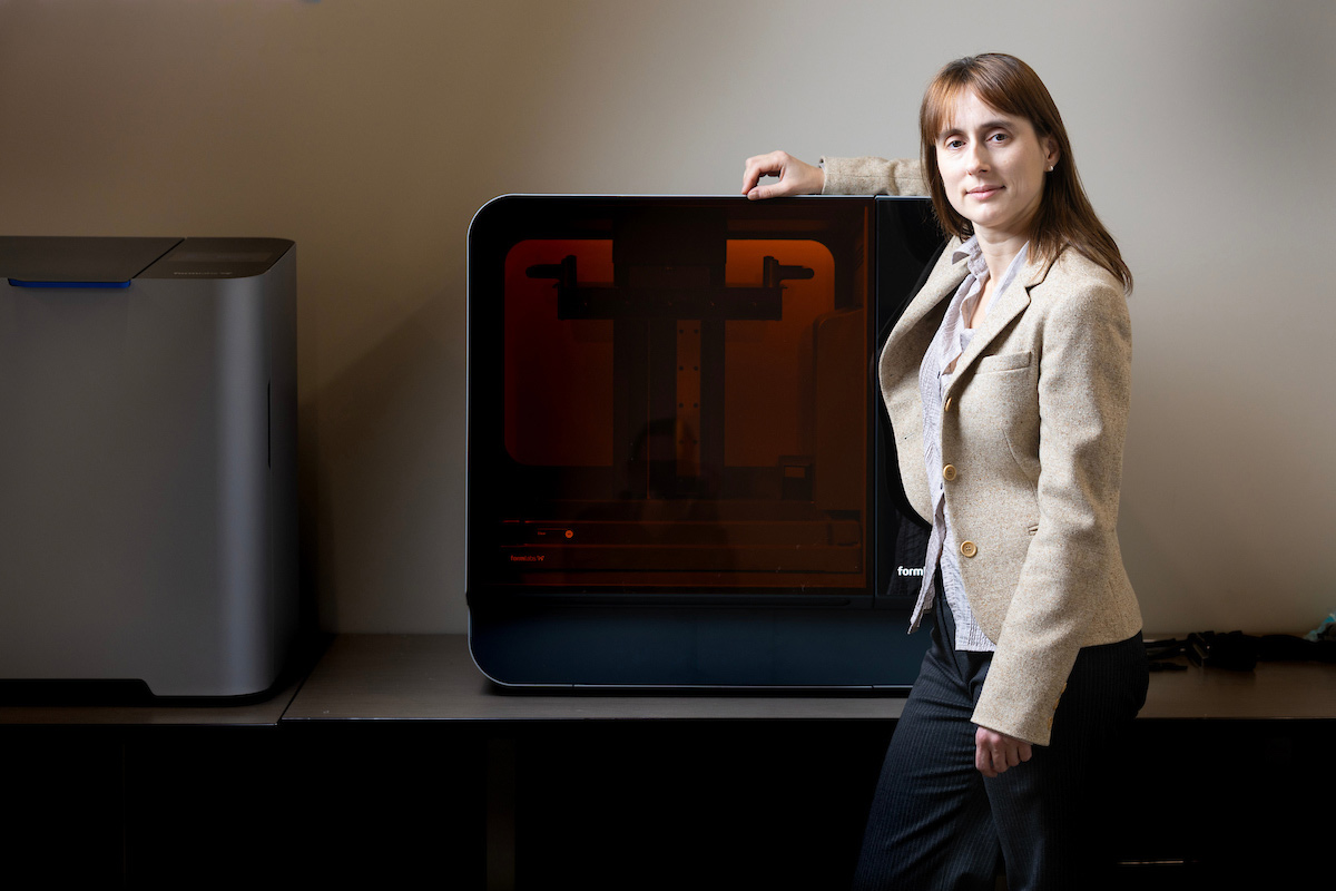 Anastasia Desyatova, Ph.D., stands near one of the printers in the the 3-D Printing Lab.