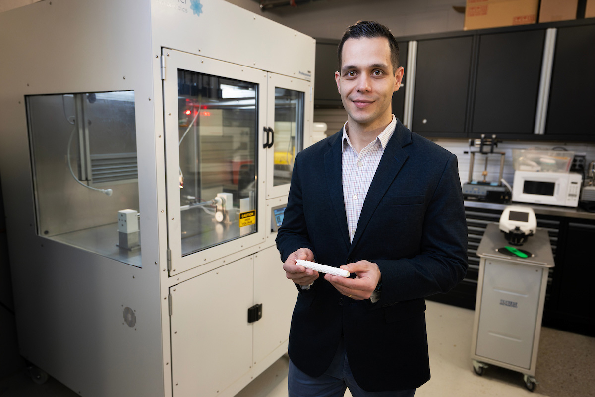 Kaspars Maleckis, Ph.D., holds a stint that is wrapped in a material created in materials lab at the Biomechanics Building.