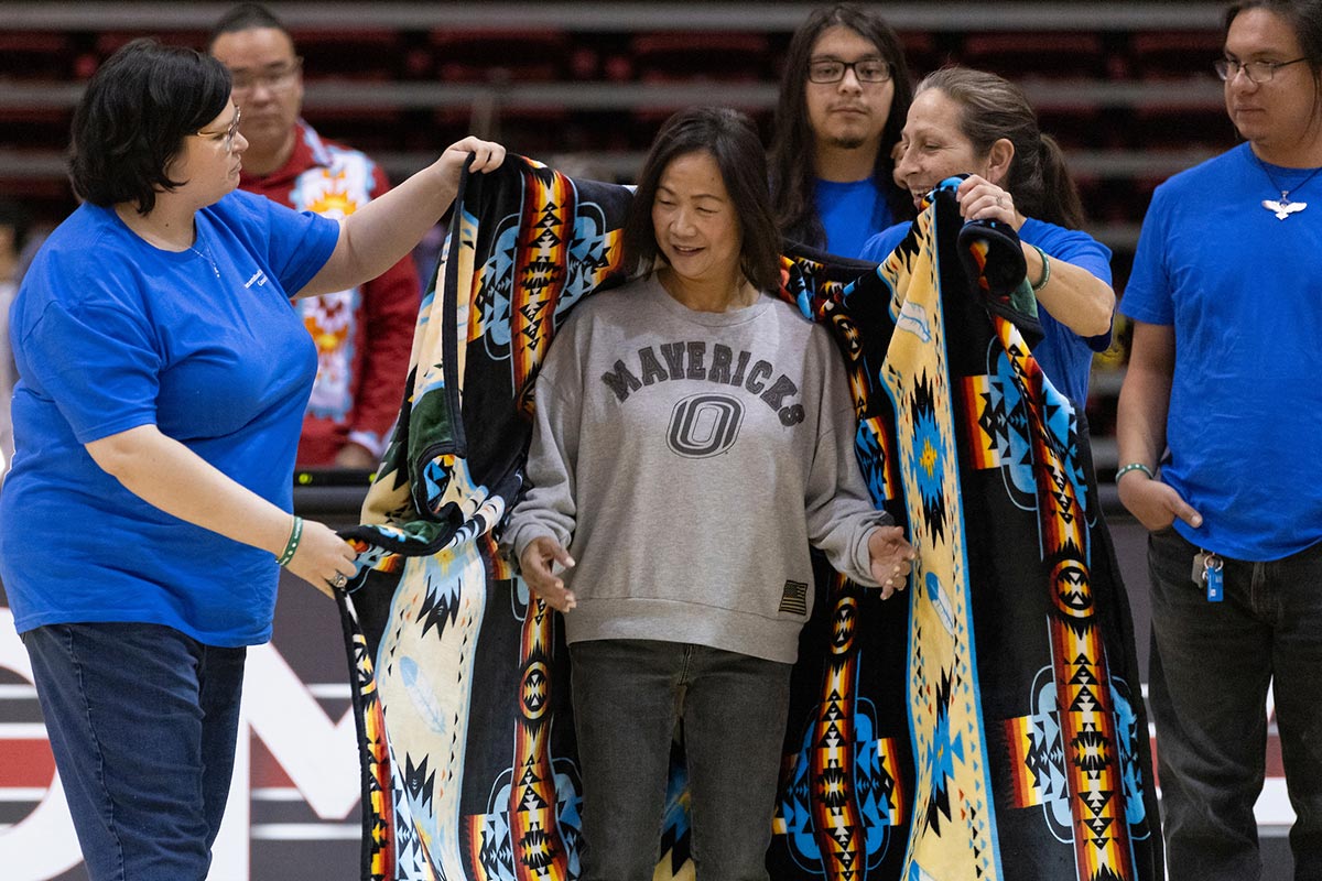 UNO Chancellor Joanne Li, Ph.D., CFA, is adorned with a traditional serape after giving opening remarks.  