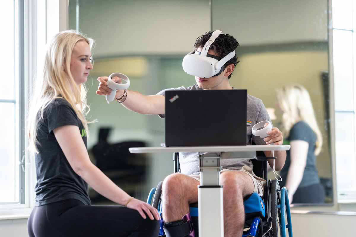 QLI Occupational Therapist, Olivia Ollis, works with a patient to utilize the VR rehabilitation technology. 