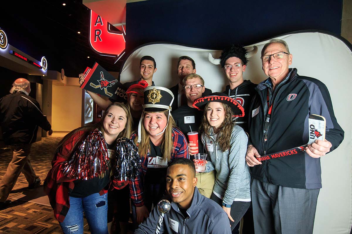 Christensen, former NU System President Hank Bounds (back row, middle), 2016 Student Body President/Regent Patrick Davlin (next to Bounds) and students attend an event at Aksarben Cinema.