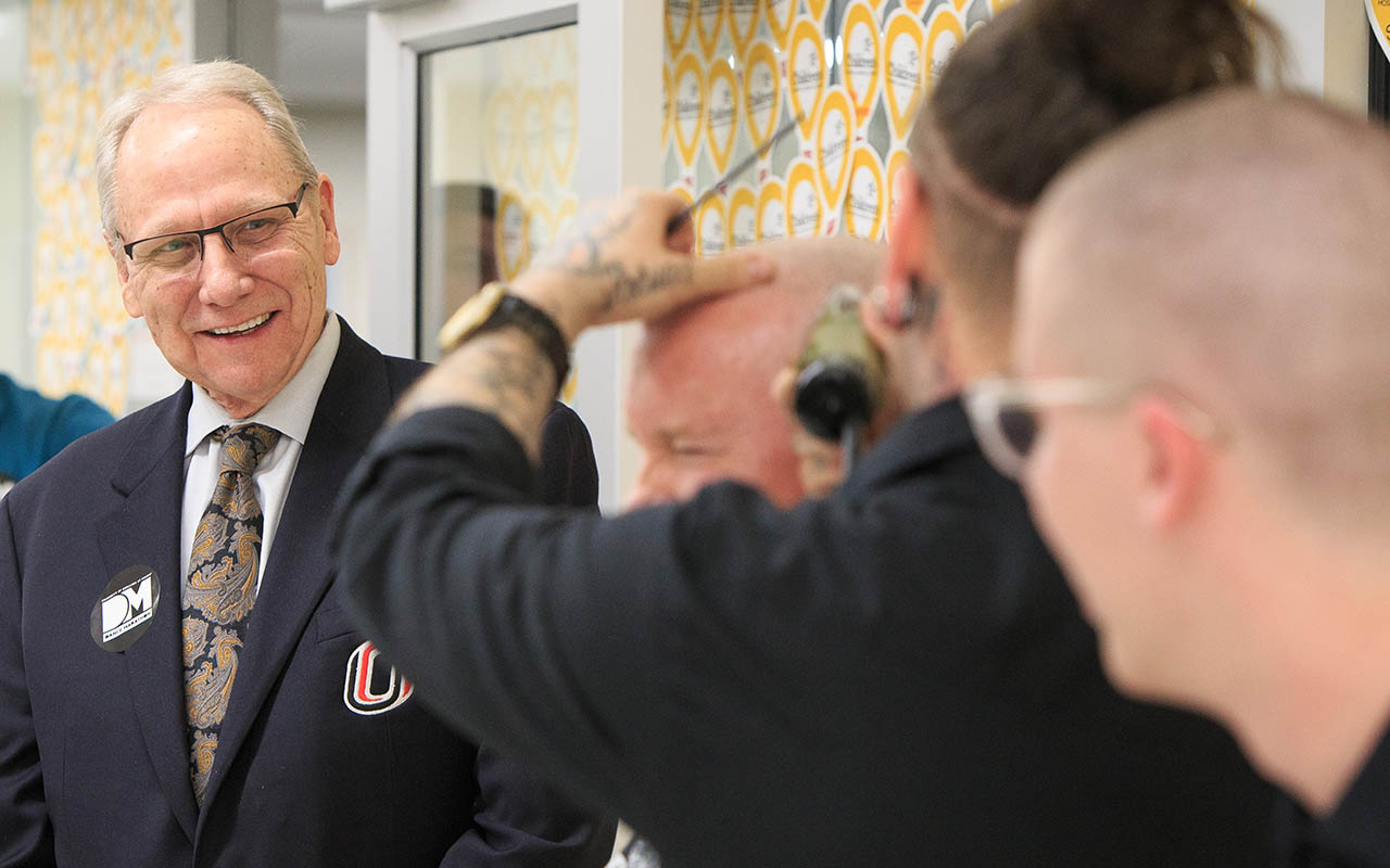 Christensen smiles as NU Regent Tim Clare has his head shaved after $5,000 was raised by UNO's Dance Marathon for the Children's Miracle Network.