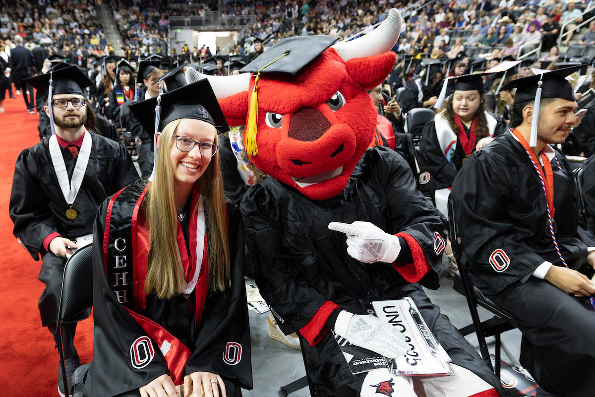 Durango sits with students awaiting the start of the commencement ceremony.