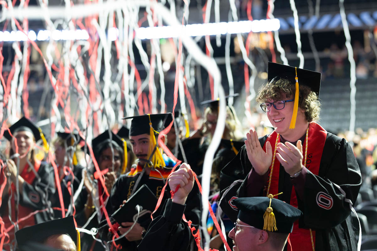 Students celebrate as the confetti cannon goes off and streamers drop at the conclusion of commencement.