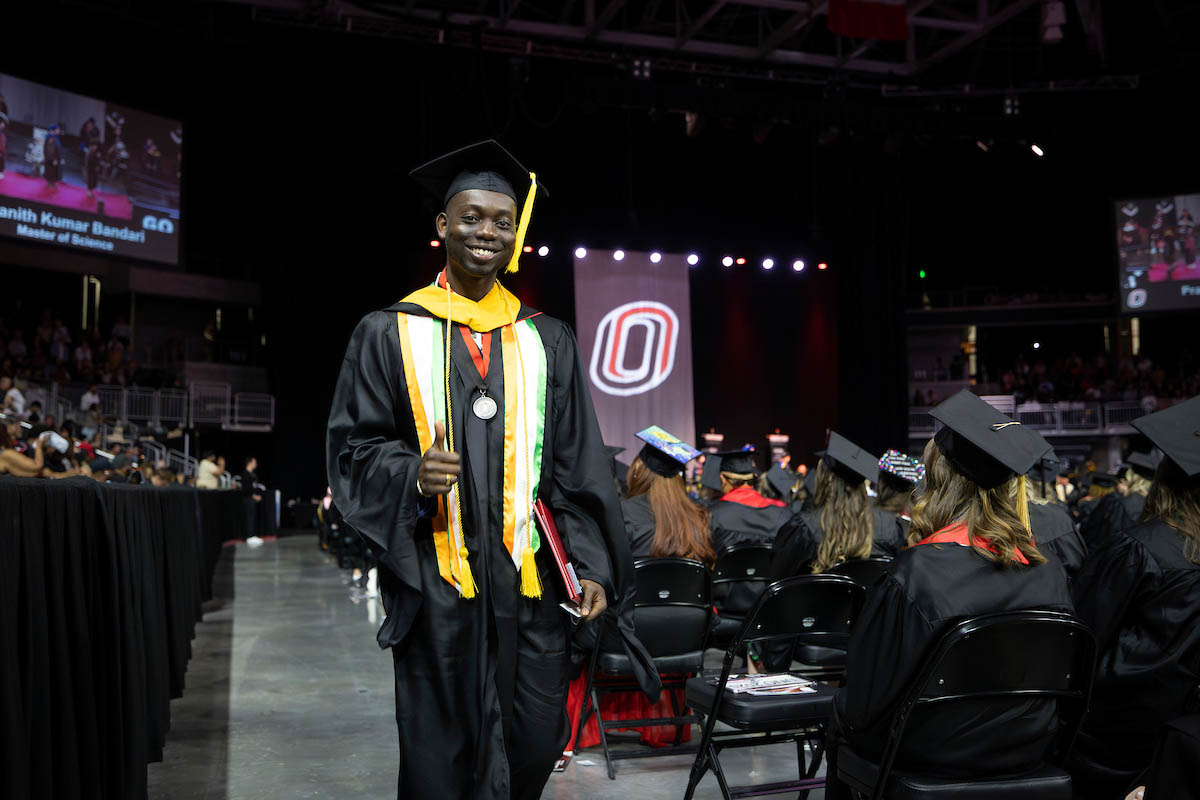 After receiving his diploma, a student gives the camera a thumbs up.