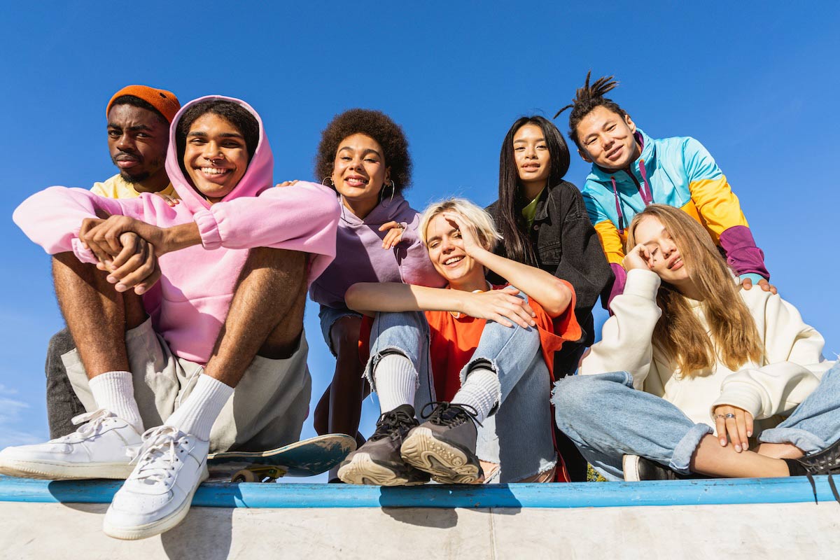 Multicultural group of young friends bonding outdoors and having fun.
