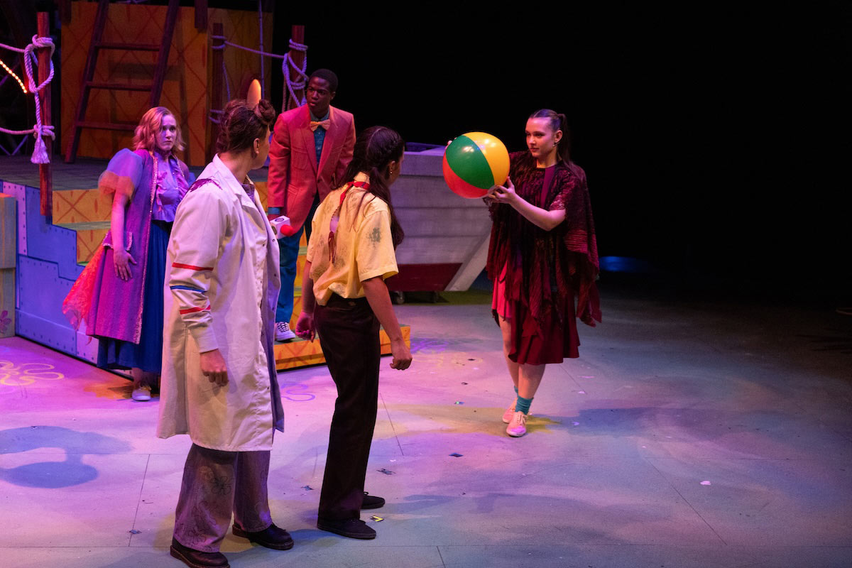 High school students perform a colorful scene from The SpongeBob Musical on stage at UNO’s Black Box Theater.