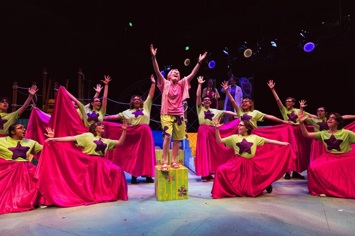 High school students perform a colorful scene from The SpongeBob Musical on stage at UNO’s Black Box Theater.