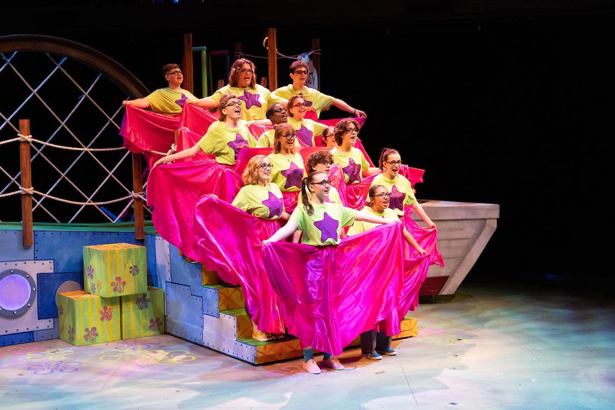 High school students perform a colorful scene from The SpongeBob Musical on stage at UNO’s Black Box Theater.