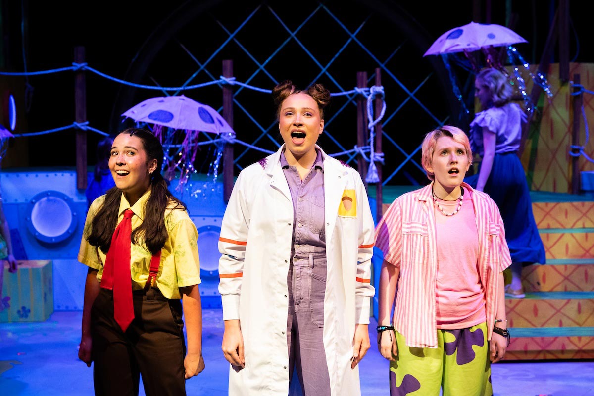High school students perform a colorful scene from The SpongeBob Musical on stage at UNO’s Black Box Theater.