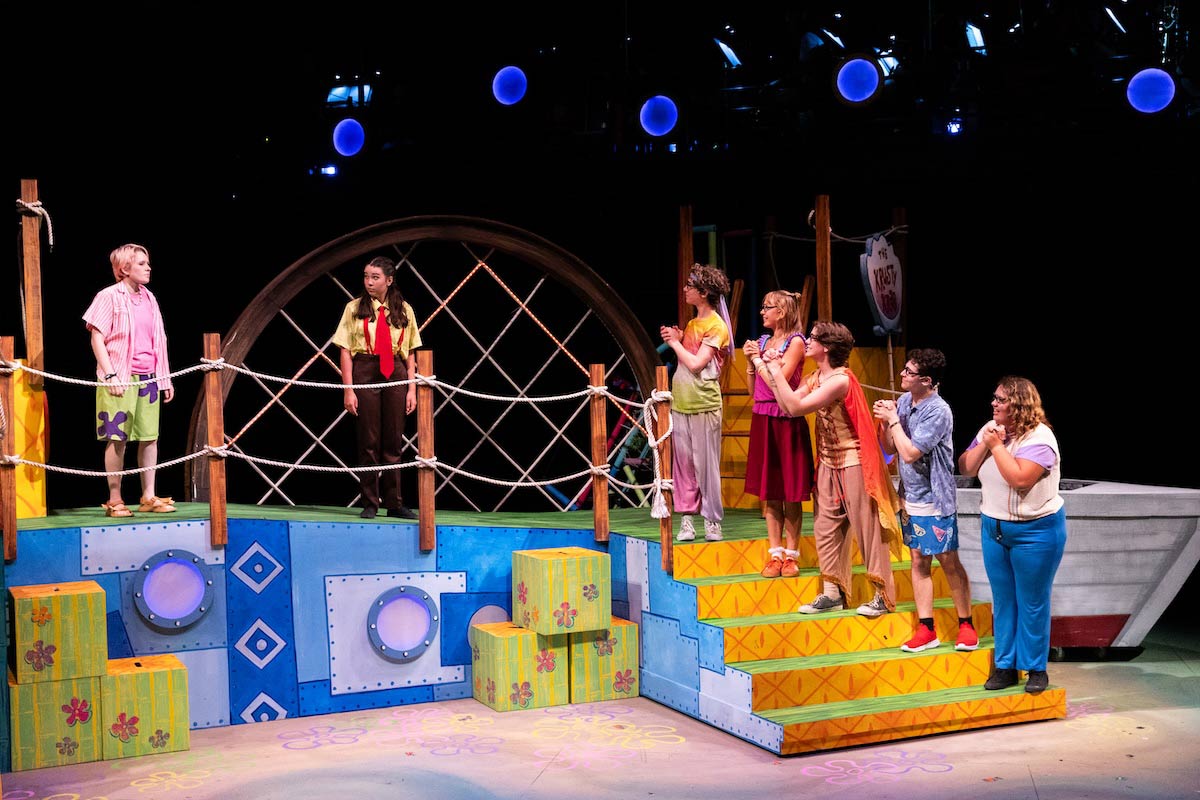 High school students perform a colorful scene from The SpongeBob Musical on stage at UNO’s Black Box Theater.