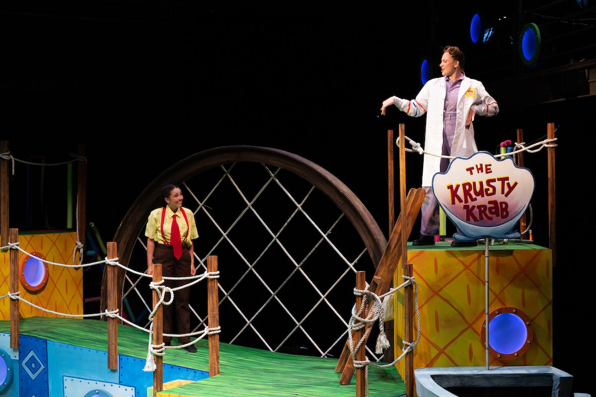 High school students perform a colorful scene from The SpongeBob Musical on stage at UNO’s Black Box Theater.