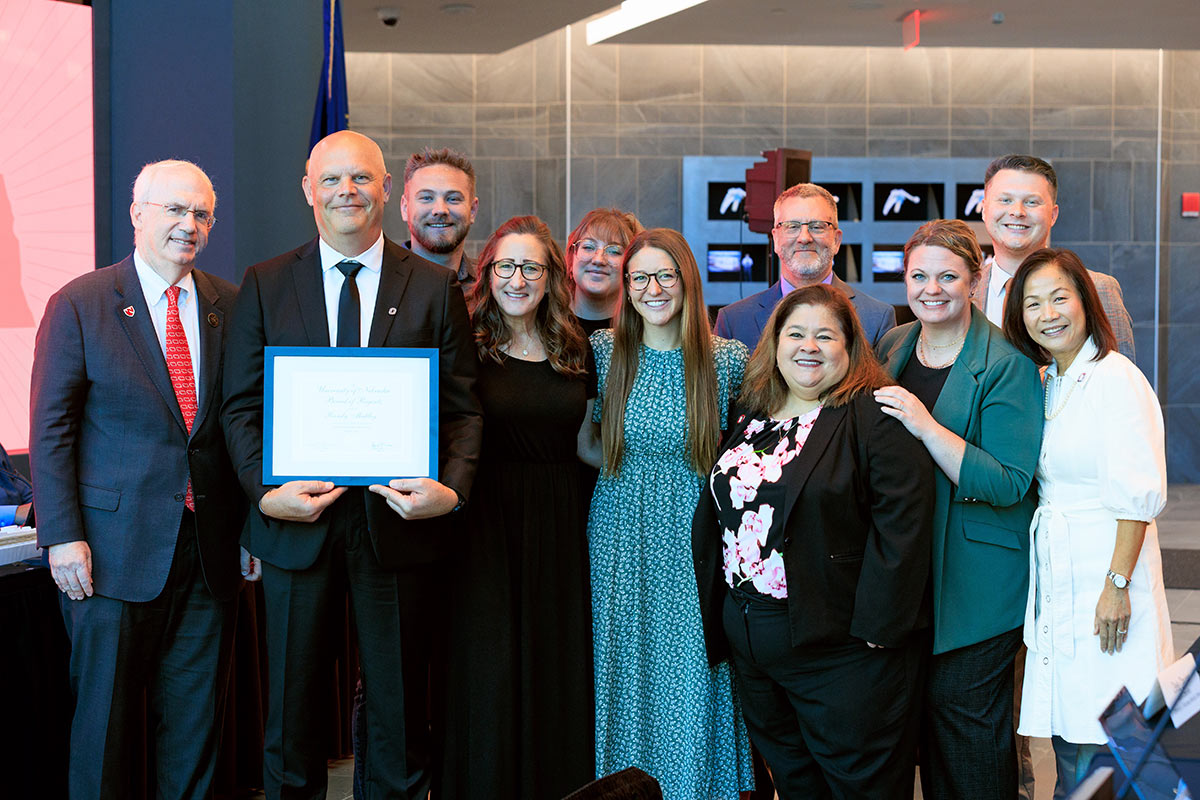 Randy Mattley receives the Kudos Award and poses for a photo with friends, family, and colleagues.