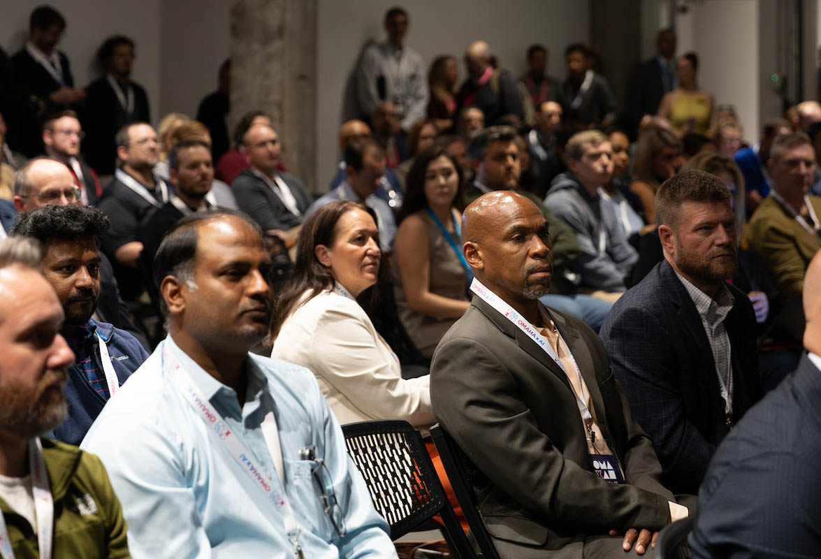 The seated audience listens attentively during a conference session.