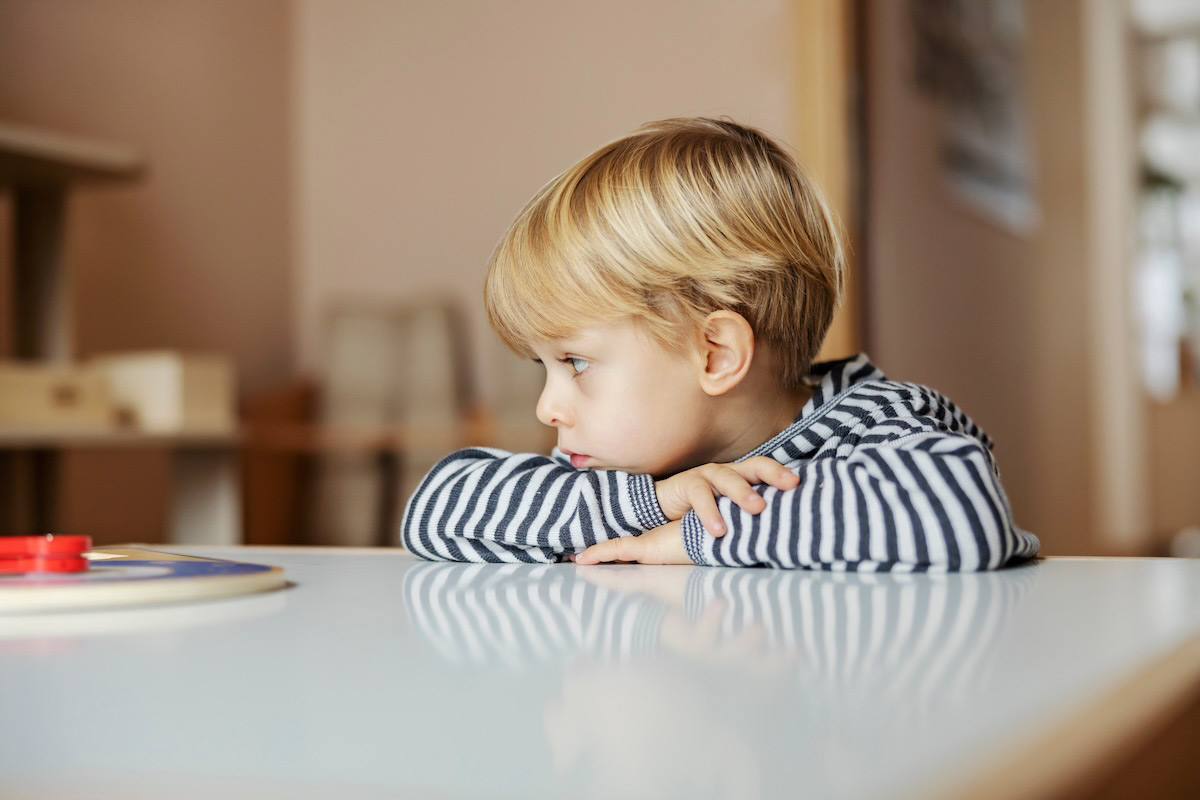 A boy is looking at the educational game at kindergarten.