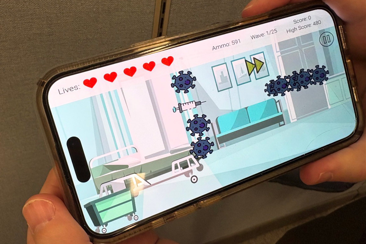 Two hands holding a phone displaying a scene from the "Zoodemic" game.