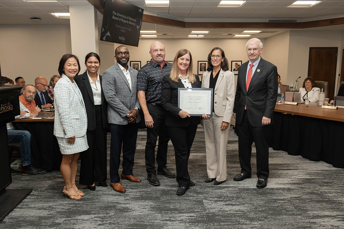 Denise Kjeldgaard poses with her certificate along with colleagues and administration officials.