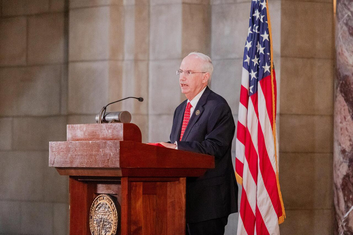 A man stands at a podium while delivering a speech