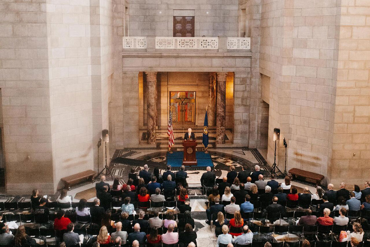 A man presents a speech to a large crowd.