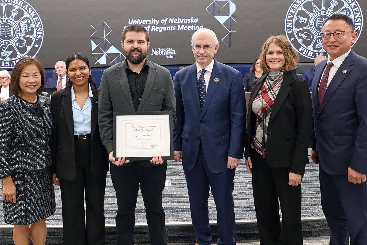 Jesse McBee poses with his certificate, colleagues, and administrators.