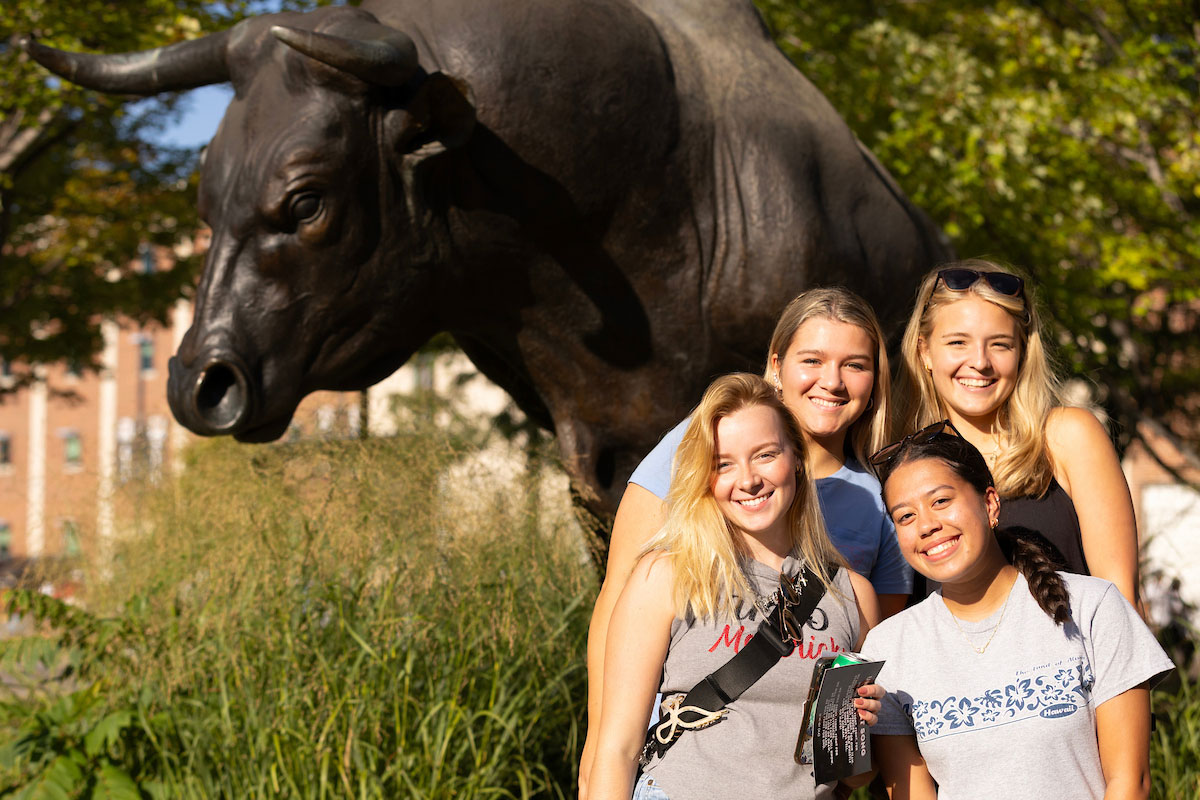 A group of students pose in front of Maverick Monument