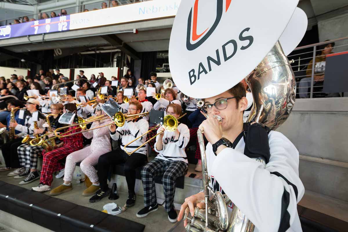 Sprit band performs while seated at a hockey game. 