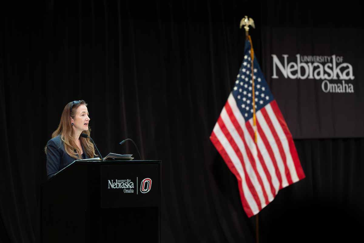 Avril Haines speaks at a podium with a University of Nebraska at Omaha logo during the Hagel Forum in Global Leadership. 