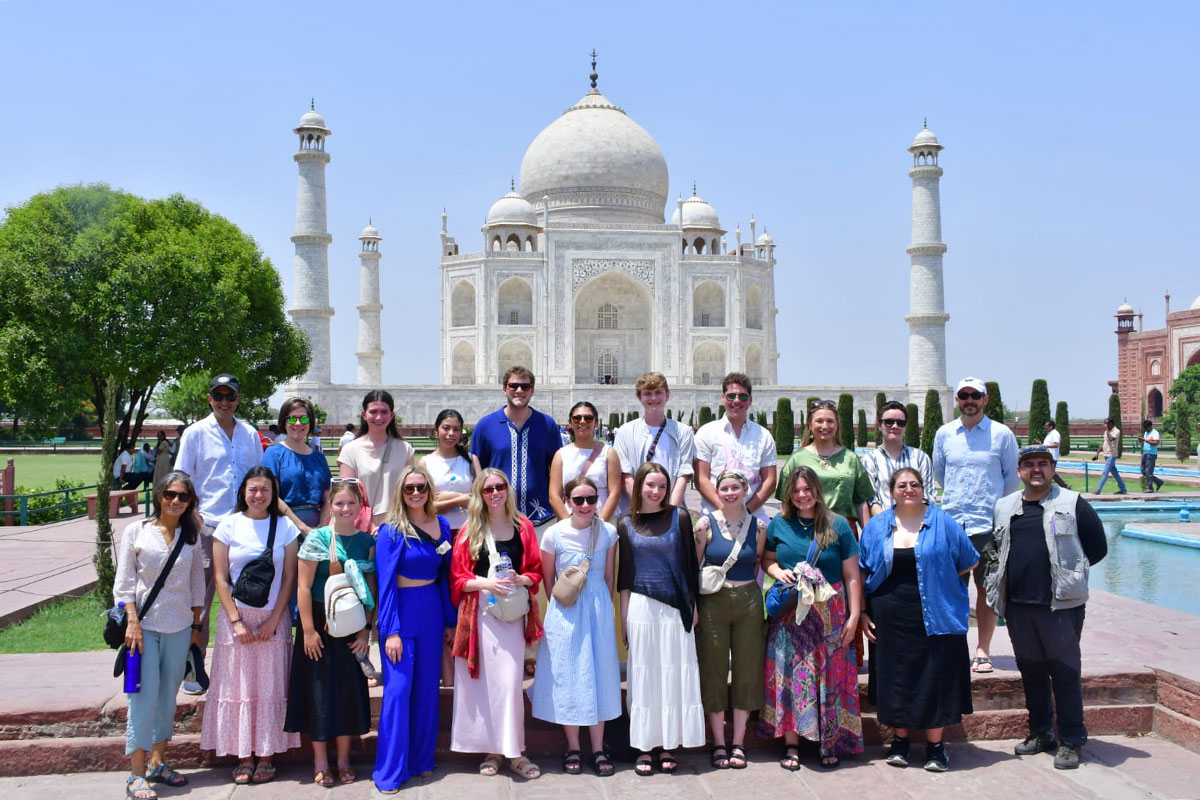 A group standing in front of the Taj Mahal.  