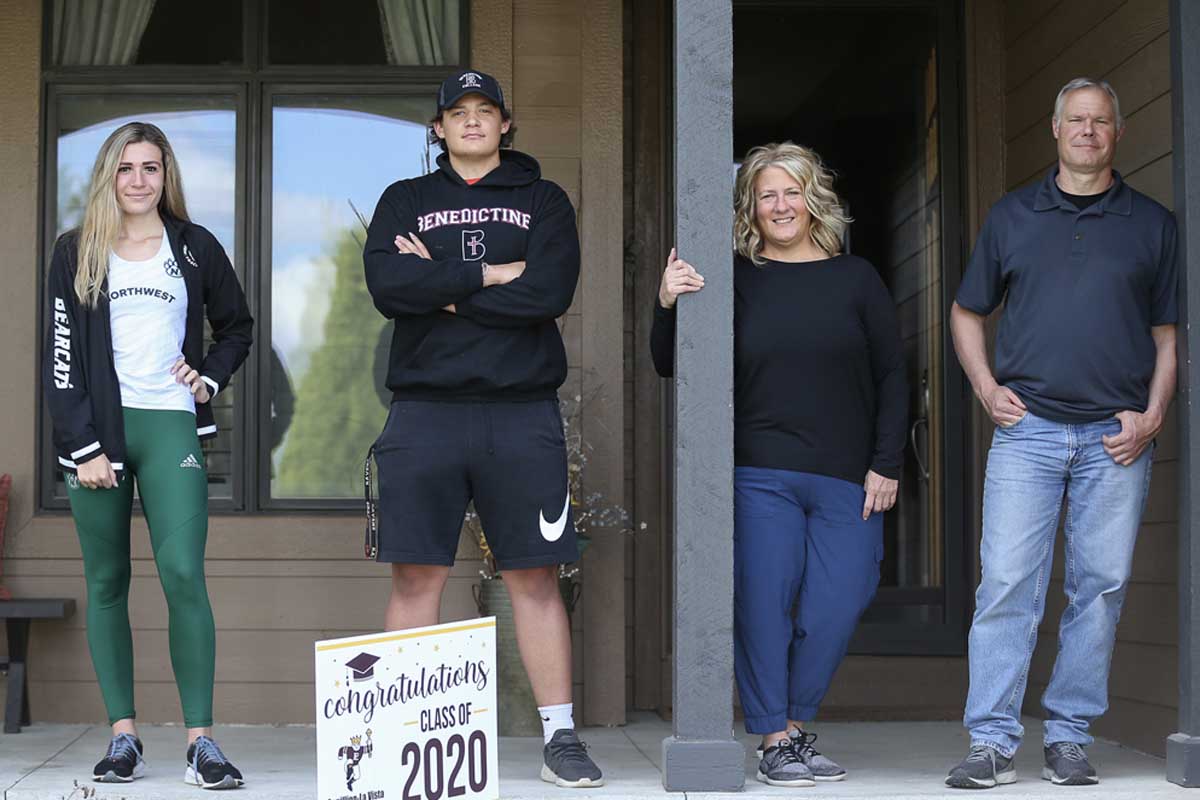 A family photo with UNO alumnus Dave Bianchi, his wife, and two of his children, standing on their porch.