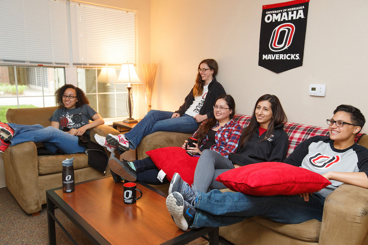 students sitting on couch in UNO apartment