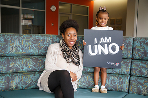 a woman and her daughter pose for a picture at uno