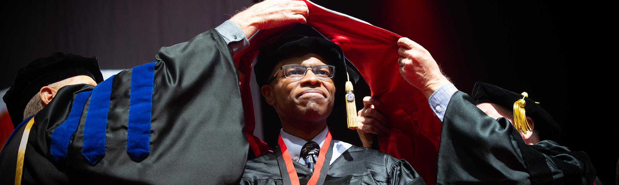 Male graduate student at commencement hooding ceremony