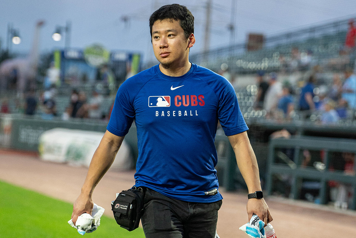 Graduate student Kenny Shibuya working on a baseball field during summer internship with the Iowa Cubs